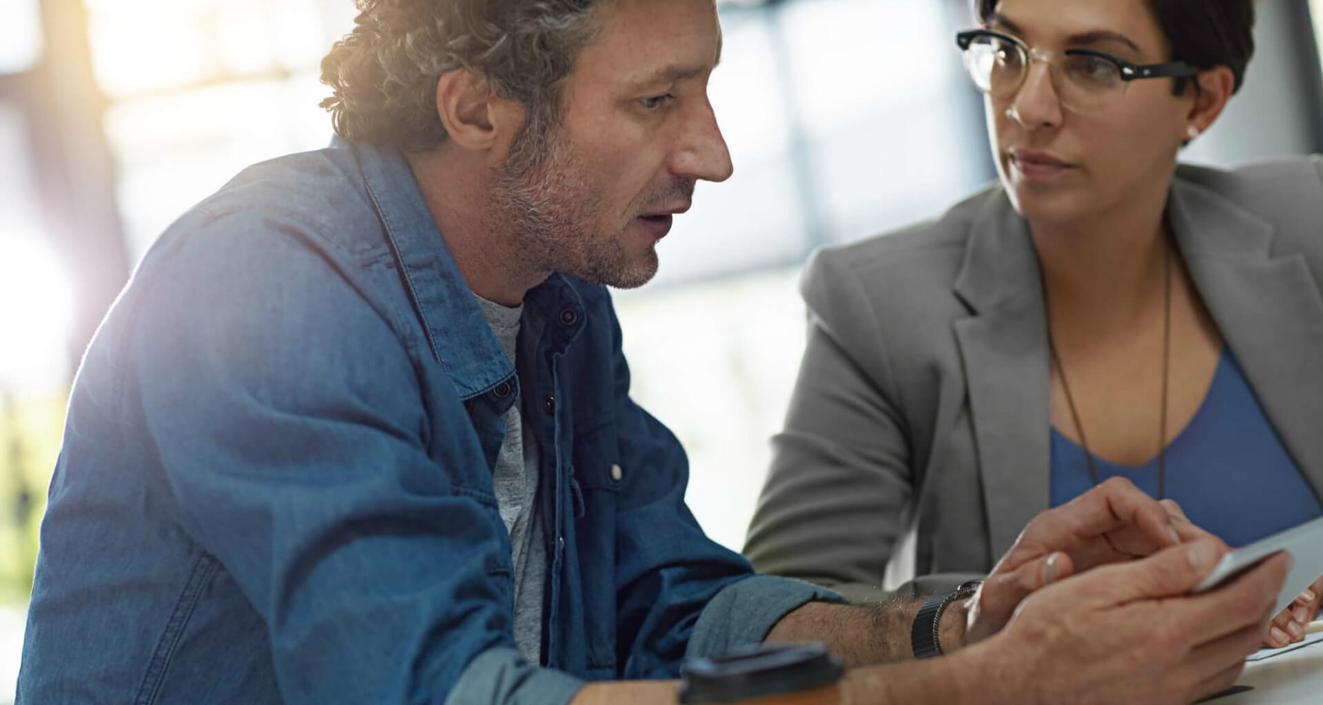 two people looking at phone tablet